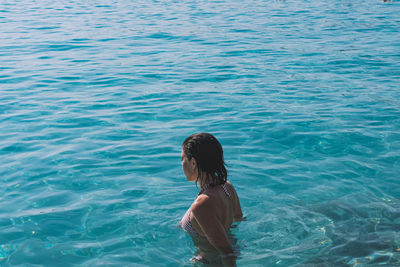 Rear view of woman swimming in sea