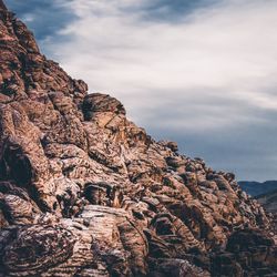 Low angle view of stack against mountain against sky