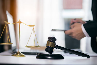 Close-up of hand holding clock on table