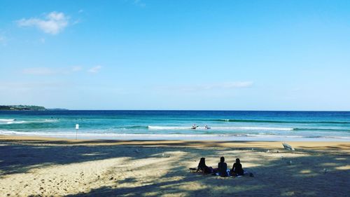 Scenic view of people relaxing on beach