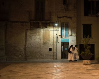 People in illuminated building at night