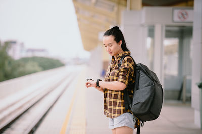 Woman looking at camera while standing against blurred background