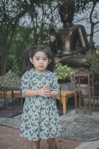 Portrait of girl standing against tree