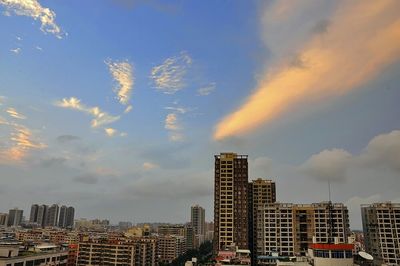 View of cityscape against cloudy sky