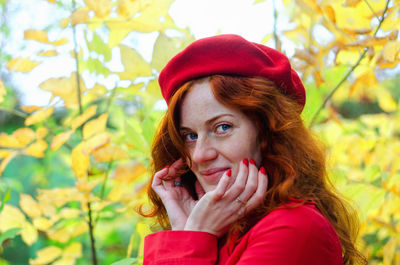 Young happy woman with red hair, freckles, blue eyes in beret in autumn park, smiling. lifestyle