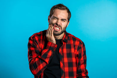 Mid adult man standing against blue background