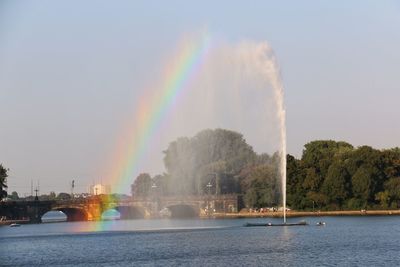 Panoramic view of rainbow over river against sky