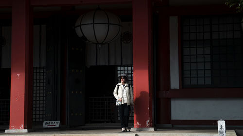 Rear view of woman standing in front of building