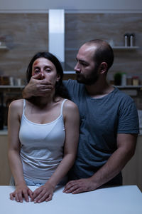 Young man and woman standing against wall