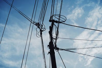 Low angle view of silhouette electricity pylon against sky