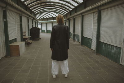 Rear view of woman walking in corridor of building