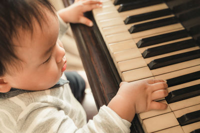 High angle view of baby boy playing piano