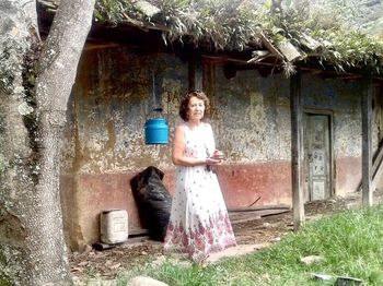 Portrait of young woman standing against wall