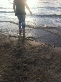 Low section of woman standing in water