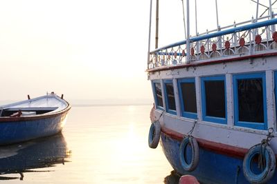 Boats moored in sea against clear sky