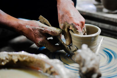 Cropped image of man molding shape on pottery wheel