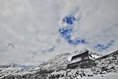 Scenic view of snow covered mountains against cloudy sky