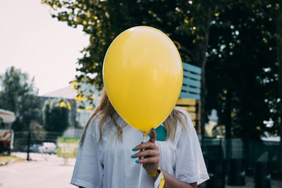 Close-up of man with balloon balloons against trees