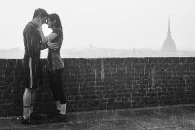 Man and woman standing against wall