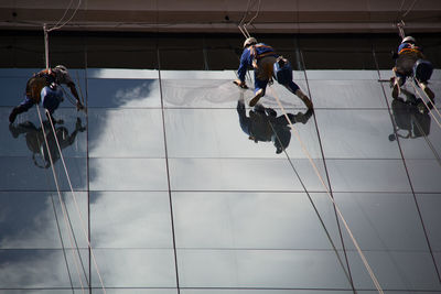 People with rope against sky