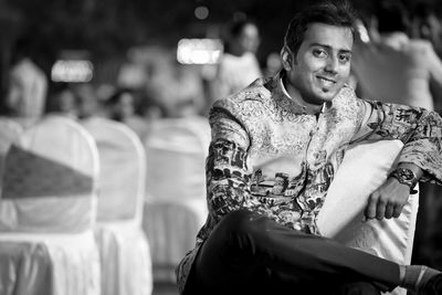 Full length of a smiling mid adult man in city at night