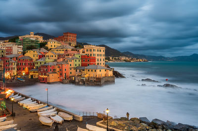 Buildings by sea against sky in city