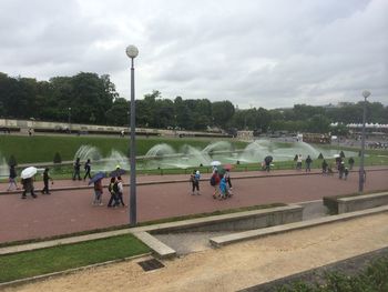 People in park against cloudy sky