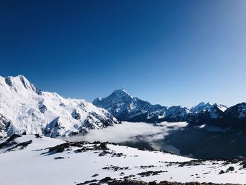 Scenic view of snowcapped mountains against clear blue sky