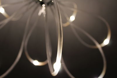 Close-up of illuminated lighting equipment against black background