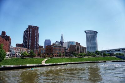 River and buildings against clear sky