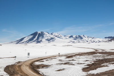 Scenic view of snowcapped mountains against blue sky