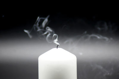 Close-up of lit candle against black background