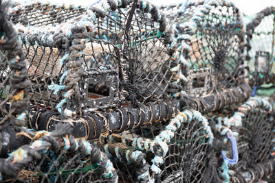 Lobster and crab fish pots netted boxes stacked in harbour uk