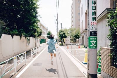 Rear view of man walking on road in city