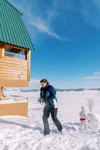 Full length of woman standing on snow covered landscape