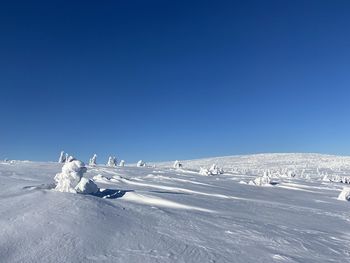 Scenic view of snow covered mountain against blue sky