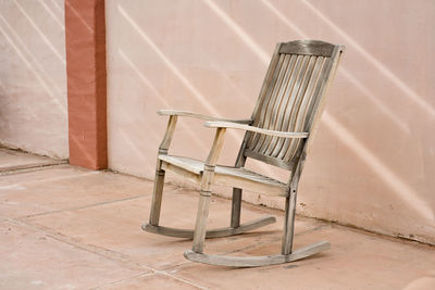 Wooden chair on floor against wall