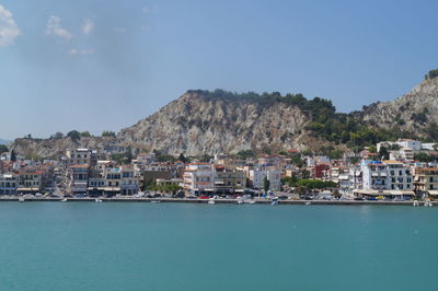 Houses by sea against sky in town