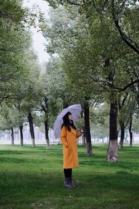 Full length of woman standing on field during rainy season