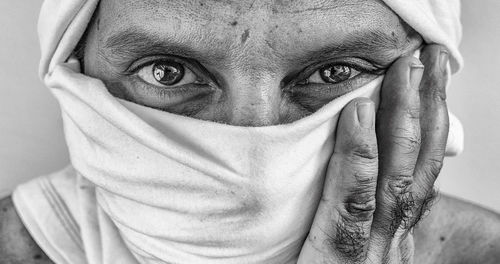 Portrait of man covering face with fabric