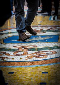 Low section of man standing on tiled floor