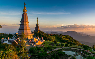 Temple by building against sky during sunset