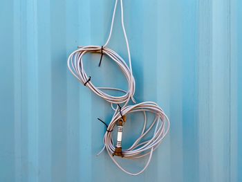 Close-up of electric lamp on table against blue wall