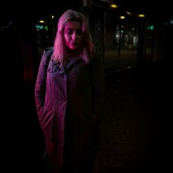 Portrait of young woman standing at night