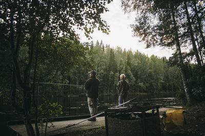 Men by trees against sky