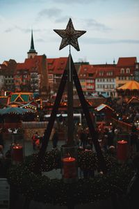 Close-up of christmas lights against buildings in city