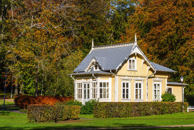 Idyllic little yellow cottage with autumn colors on the trees