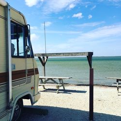 Van at shore of beach against sky