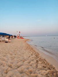 Scenic view of beach against clear sky during sunset