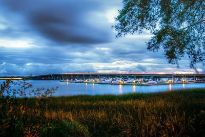 Bridge over river against cloudy sky